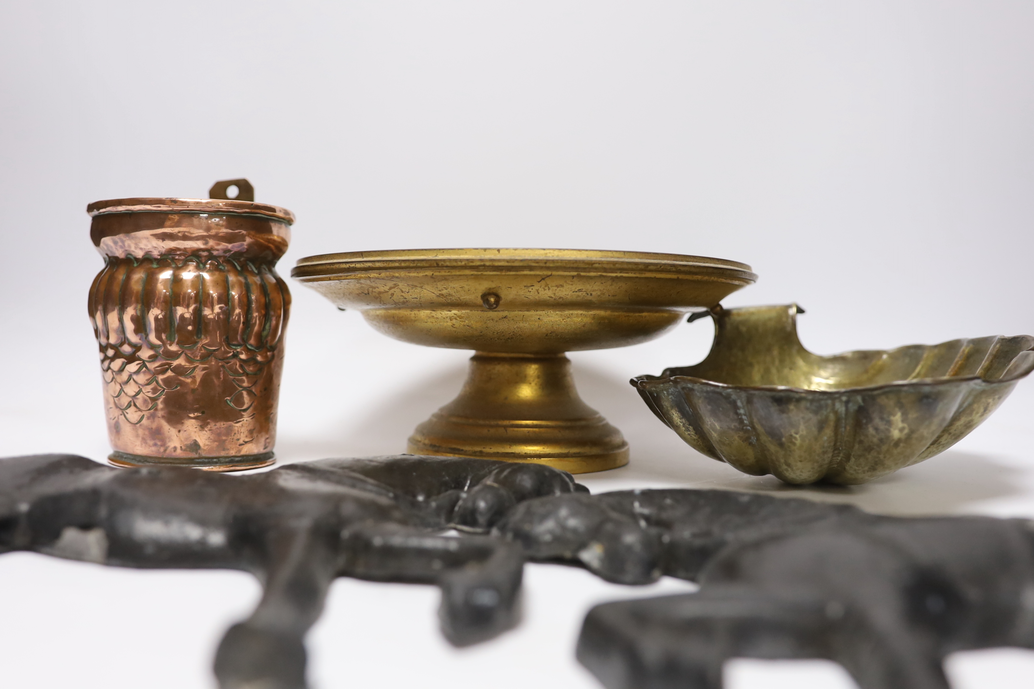 A group of metalware to include a pair of lead ‘horse’ wall mounts, a copper wall pocket, a, brass ‘scallop shell’ dish, a telescopic three pronged fork and an alabaster pedestal dish